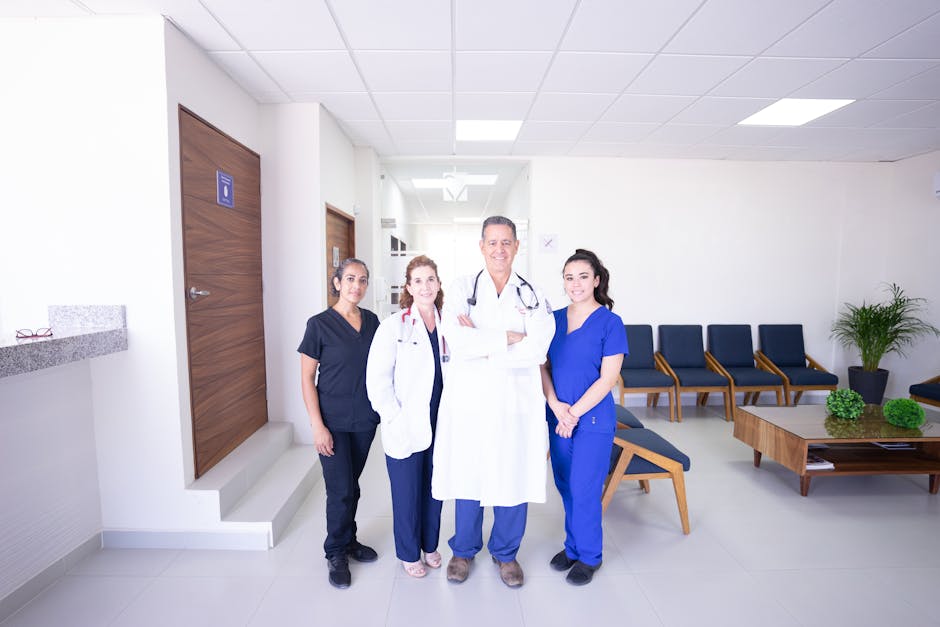 Diverse medical practitioners in uniforms, smiling in a modern hospital waiting area.