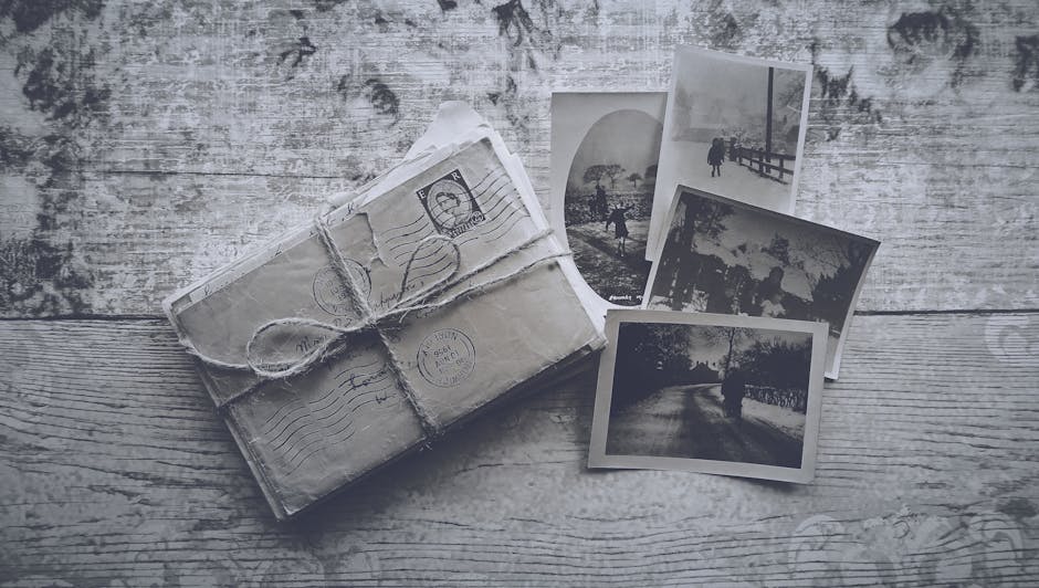 Flatlay of vintage letters tied with twine and black and white photos on a wooden surface.